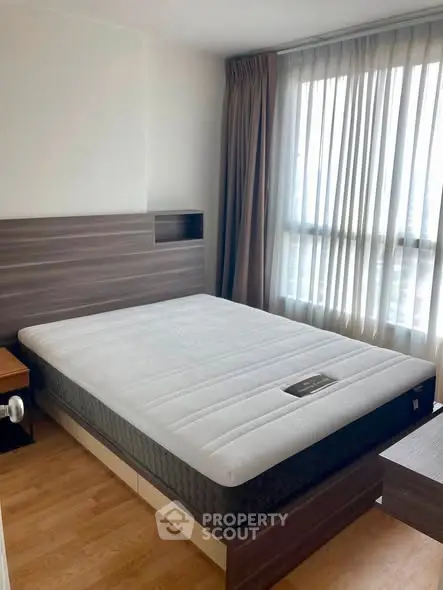 Modern bedroom with large window and stylish wooden furniture