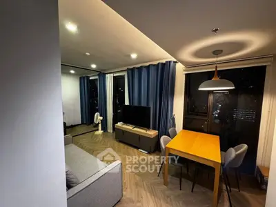 Modern living room with stylish dining area and city view, featuring elegant lighting and contemporary furniture.