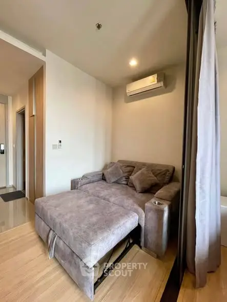 Cozy living room with modern sofa and air conditioning in a stylish apartment.