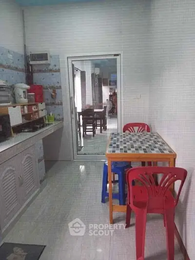 Cozy kitchen with tiled backsplash and compact dining area in a modern home.