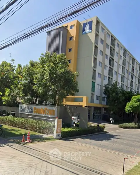 Modern condominium building with lush greenery and clear blue sky