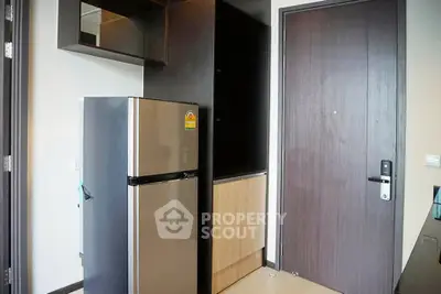 Modern apartment entrance with sleek refrigerator and stylish cabinetry