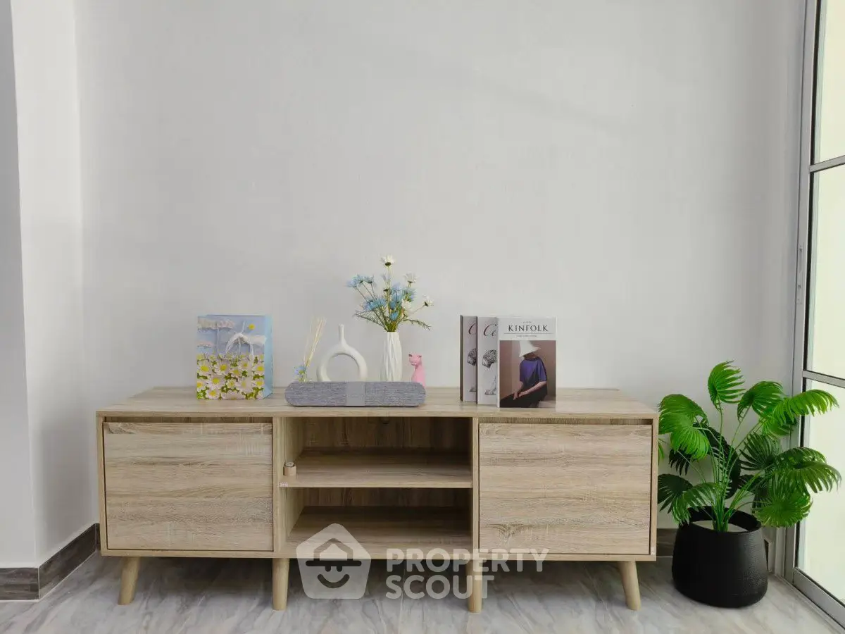 Modern minimalist living room with stylish wooden console and decorative accents.