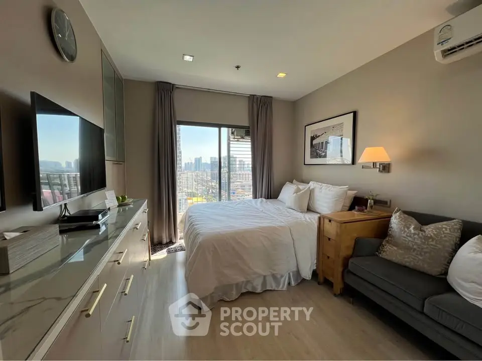 Modern bedroom with city view, stylish decor, and natural light.