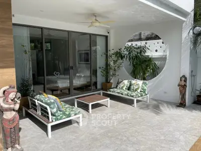 Stylish outdoor patio with modern furniture and tropical decor, perfect for relaxation and entertaining.