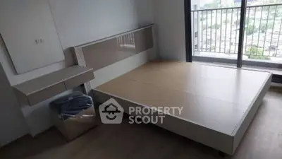 Modern bedroom with large window and city view, featuring minimalist furniture and sleek design.