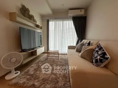 Cozy living room with modern decor and large TV, perfect for relaxation.