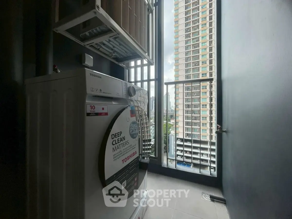 Modern condo balcony with washing machine and city view