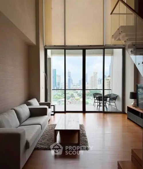 Spacious living room with modern decor and stunning city view from large windows.