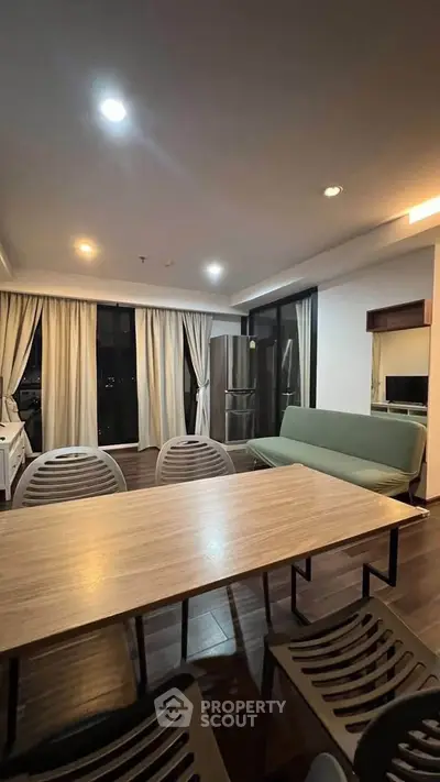 Modern living room with dining area and large windows in a stylish apartment.