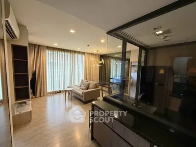 Modern living room with floor-to-ceiling windows and stylish furniture in a contemporary apartment.
