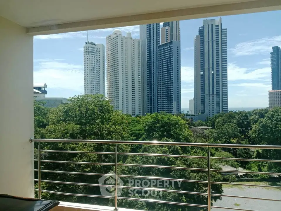 Stunning cityscape view from a modern balcony overlooking lush greenery and skyscrapers.