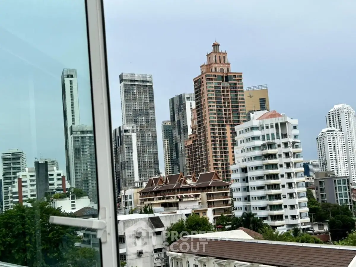 Stunning cityscape view from a modern apartment window showcasing diverse architectural styles.