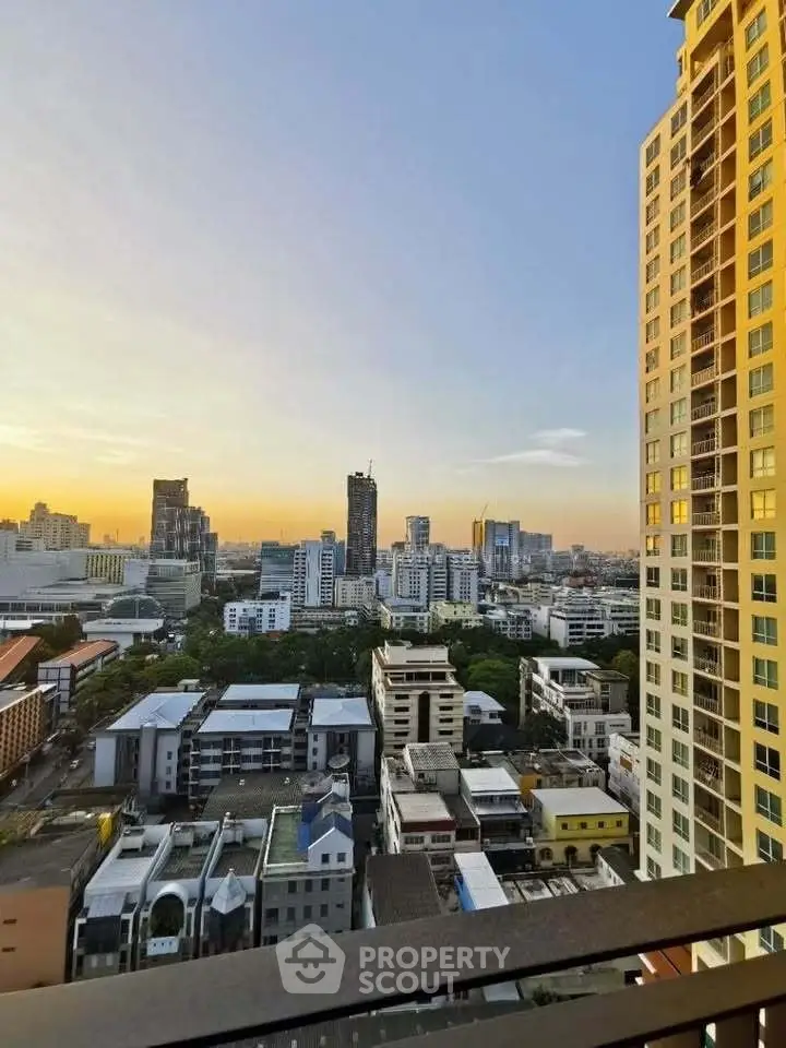 Stunning cityscape view from high-rise balcony at sunset, showcasing urban skyline and vibrant architecture.