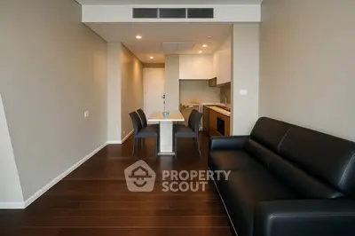 Modern apartment living room with sleek furniture and open kitchen layout.