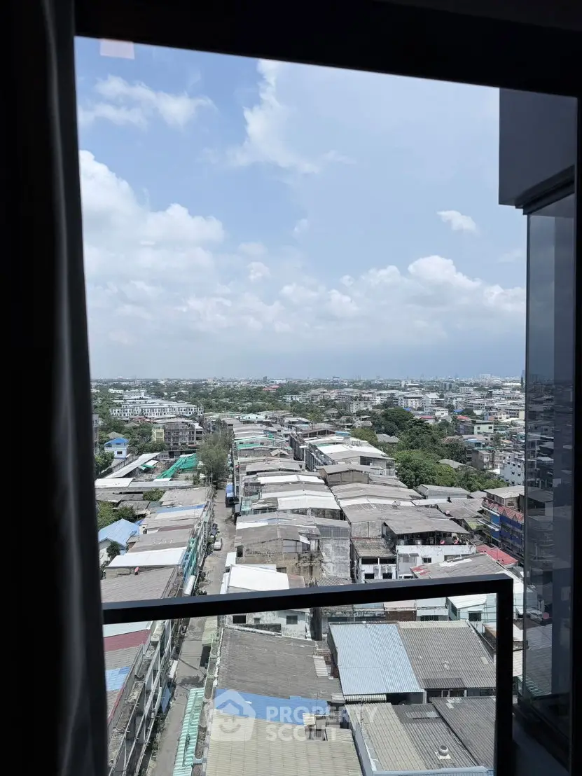 Stunning cityscape view from a high-rise balcony, showcasing expansive urban landscape under a clear blue sky.