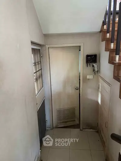 Cozy interior hallway with staircase and door, ideal for compact living spaces.