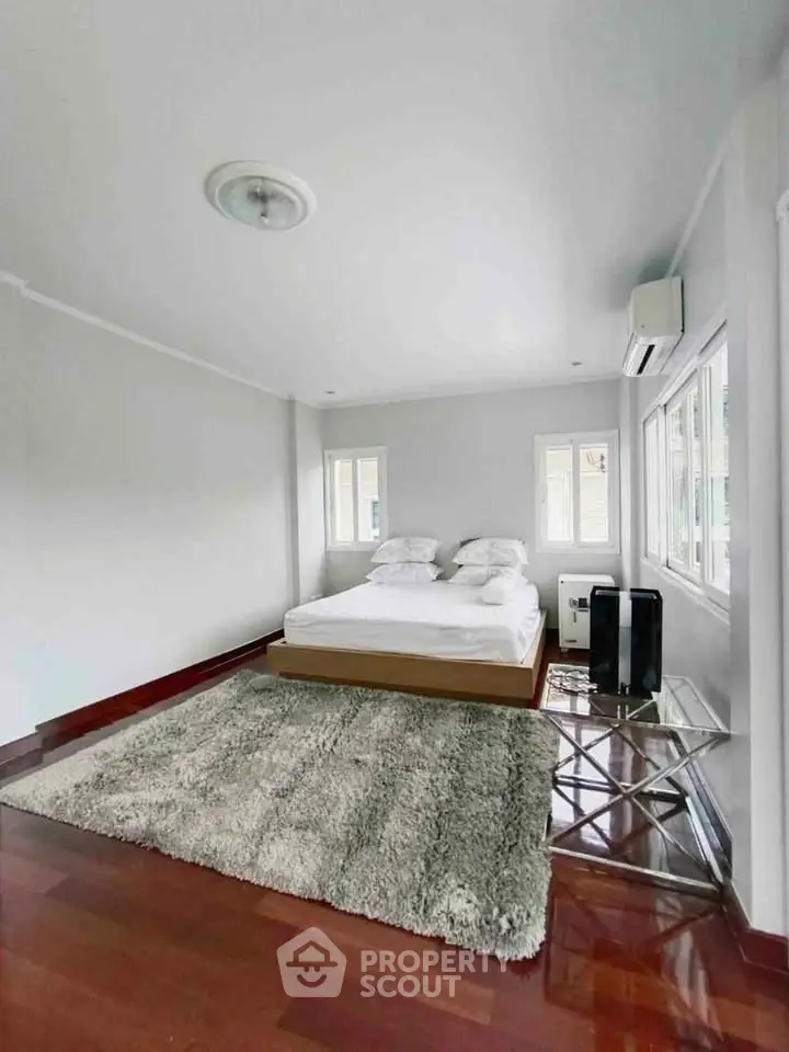 Spacious bedroom with modern decor and large windows for natural light