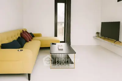Modern living room with yellow sofa and sleek TV setup, perfect for relaxation and entertainment.