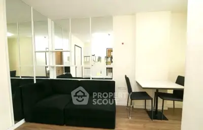 Modern living room with black sofa and mirrored wall design