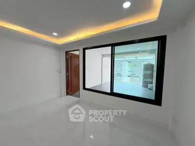 Modern empty room with large window and recessed lighting