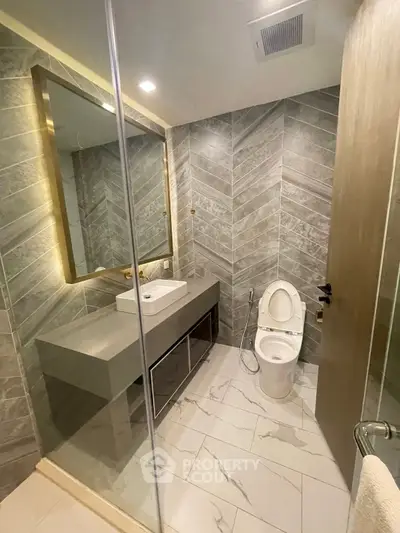 Luxurious modern bathroom with elegant tile design and sleek fixtures.