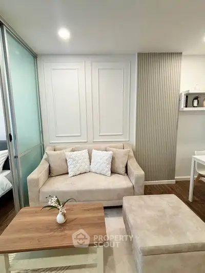 Modern living room with beige sofa, elegant paneling, and cozy decor