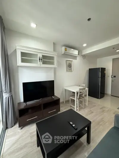 Modern living room with sleek furniture and open kitchen layout in a stylish apartment.