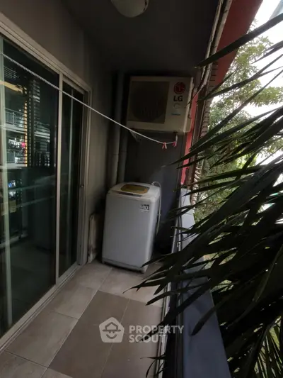 Cozy balcony with washing machine and air conditioning unit, perfect for urban living.