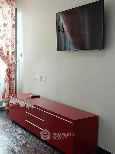 Modern living room with sleek red TV console and wall-mounted flat screen TV.