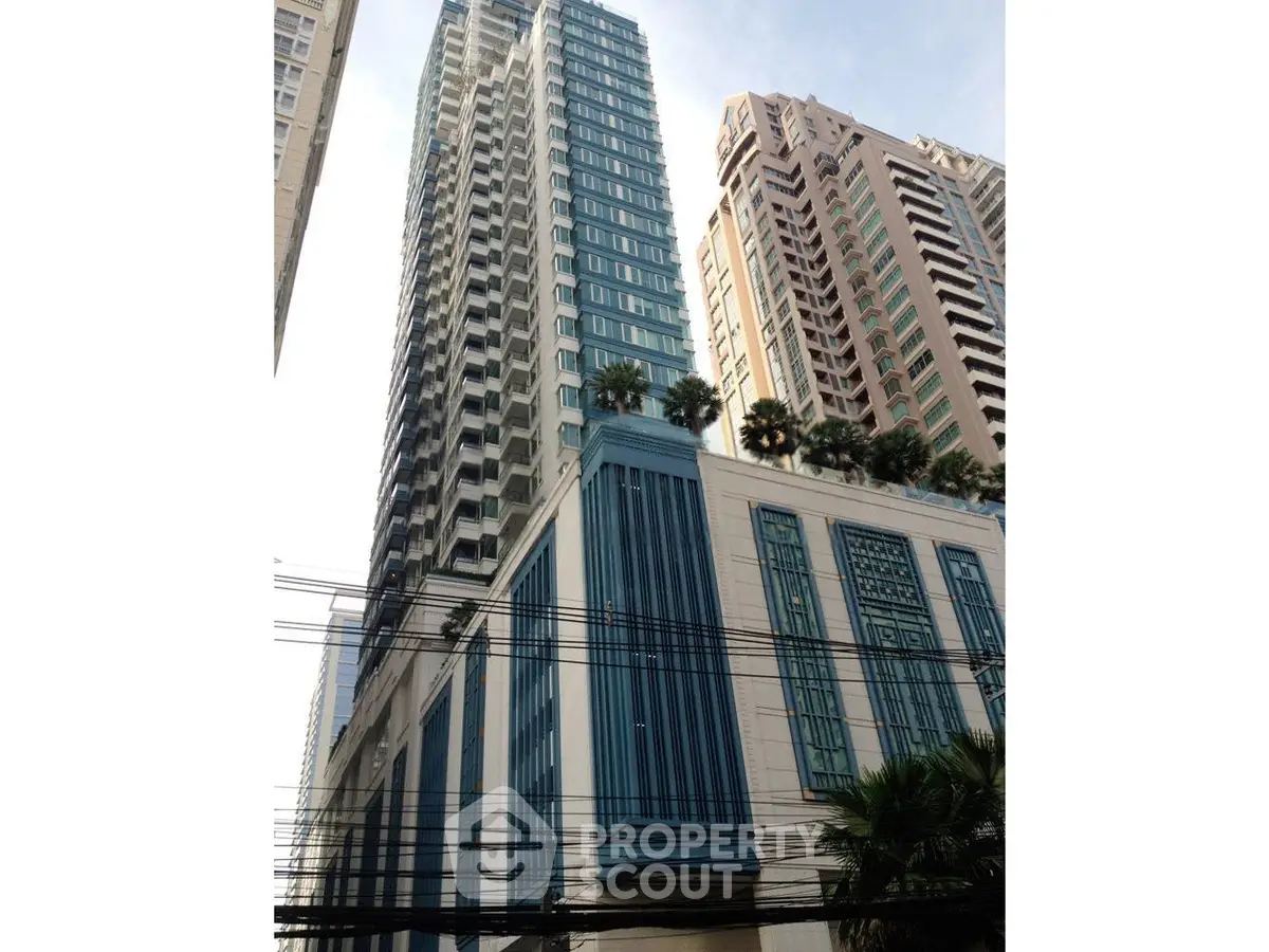 Stunning high-rise building with modern architecture and lush rooftop greenery in urban setting.