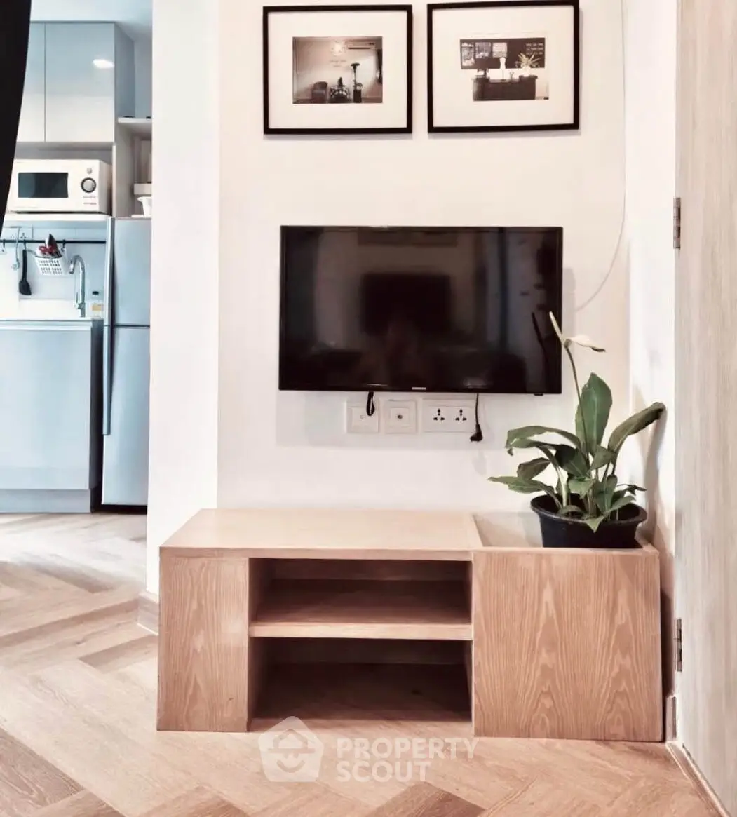 Modern living room with wall-mounted TV and stylish kitchen view