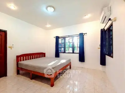 Spacious bedroom with large window and air conditioning in a minimalist style.