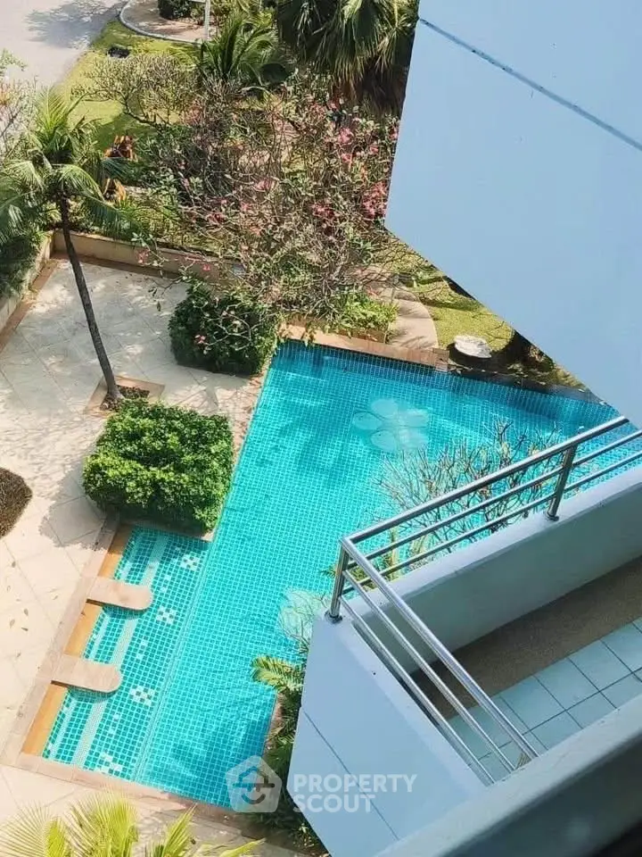 Stunning aerial view of a luxurious poolside area with lush greenery and modern architecture.