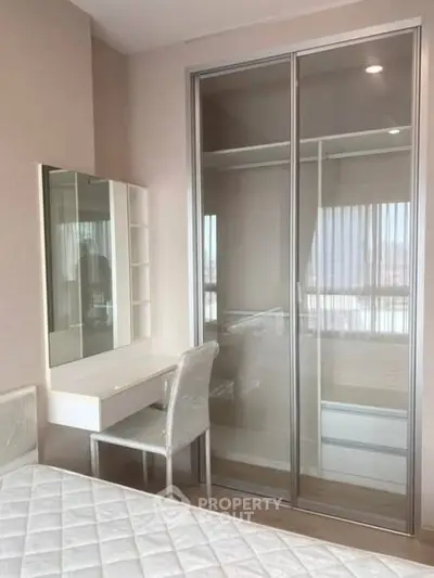 Modern bedroom with mirrored closet and stylish vanity in a bright apartment.