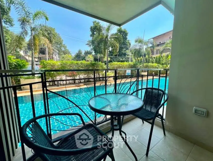 Charming balcony with pool view, perfect for relaxation and outdoor dining.