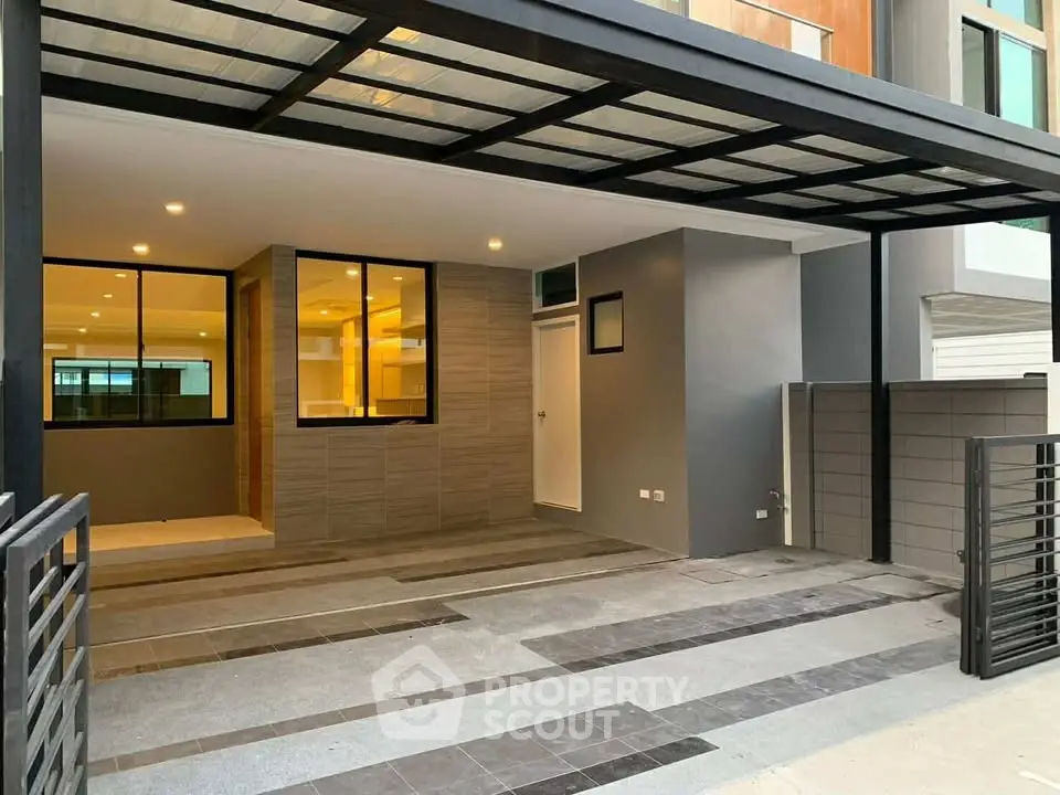Modern townhouse entrance with sleek design and spacious parking area.