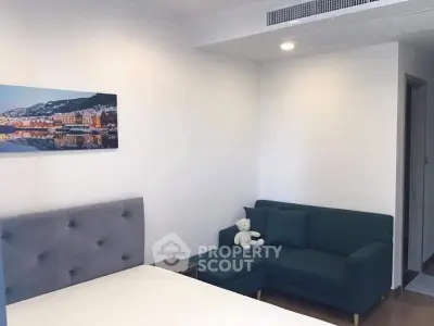 Modern bedroom with cozy sofa and stylish decor in a contemporary apartment.