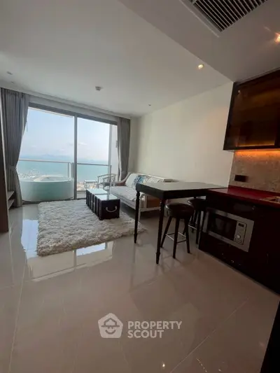 Modern living room with ocean view, sleek furniture, and open layout in a luxury apartment.