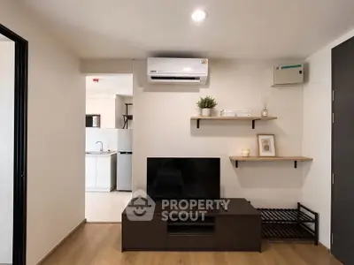 Modern living room with sleek TV stand, air conditioning, and minimalist decor.