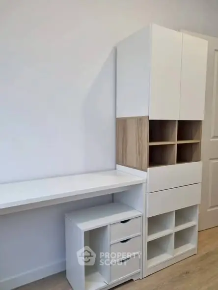 Modern study room with sleek white furniture and ample storage space.