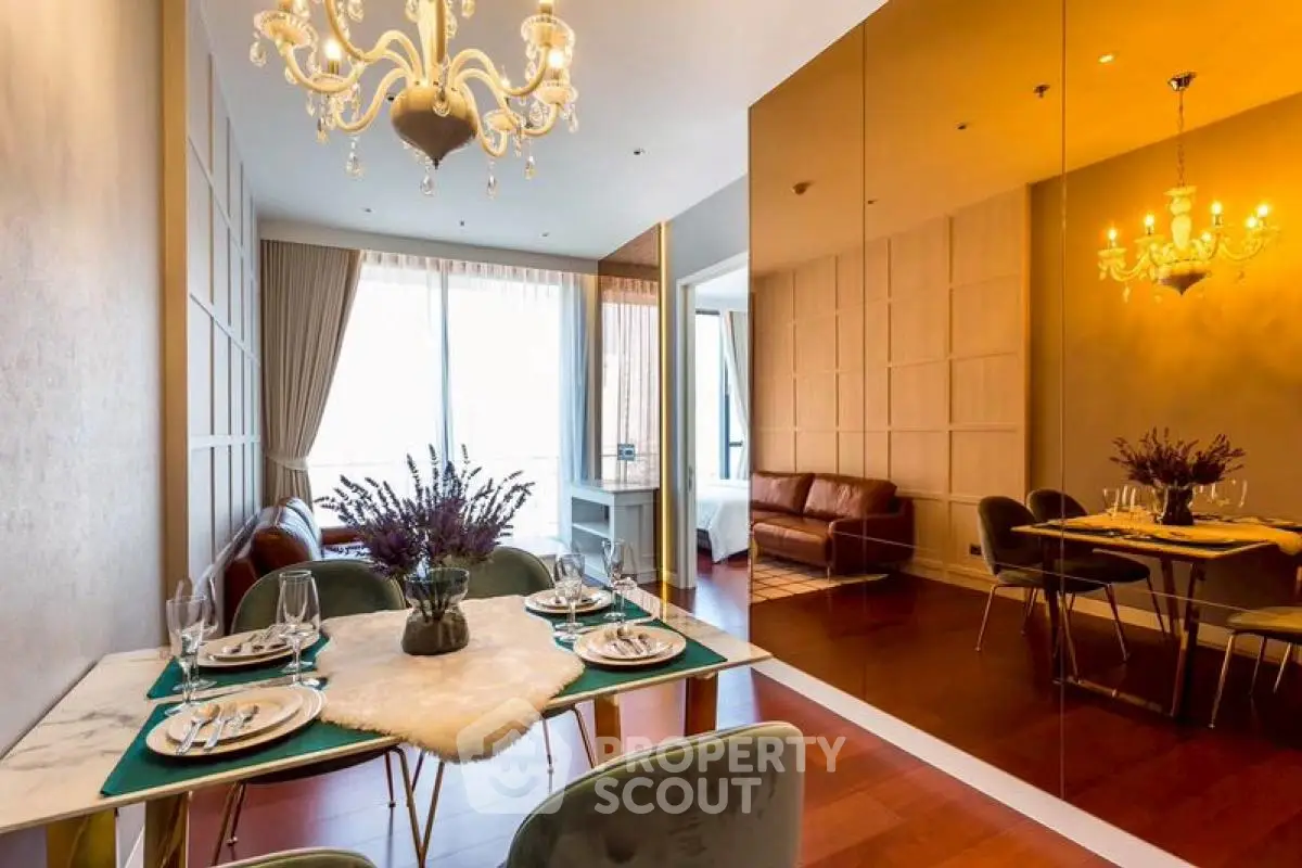 Luxurious dining and living area with elegant chandelier and mirrored wall