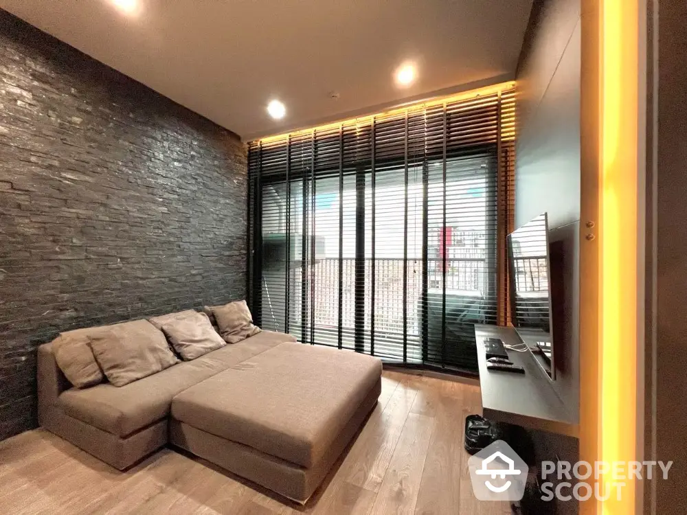 Modern living room with sleek design and large windows offering natural light and city views.