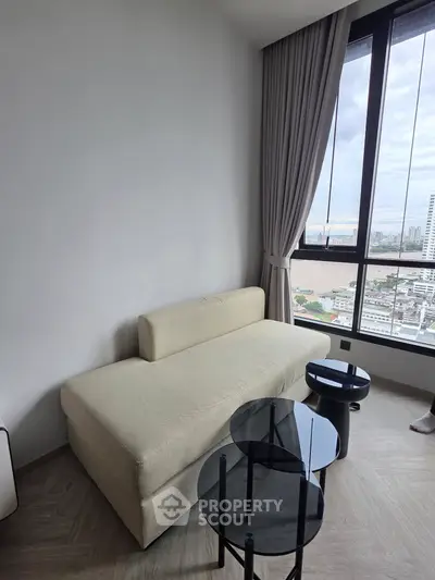 Modern living room with beige sofa and city view through large window