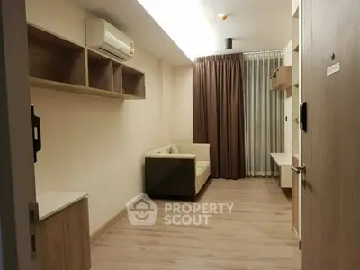Modern living room with wooden flooring and cozy sofa in a compact apartment.