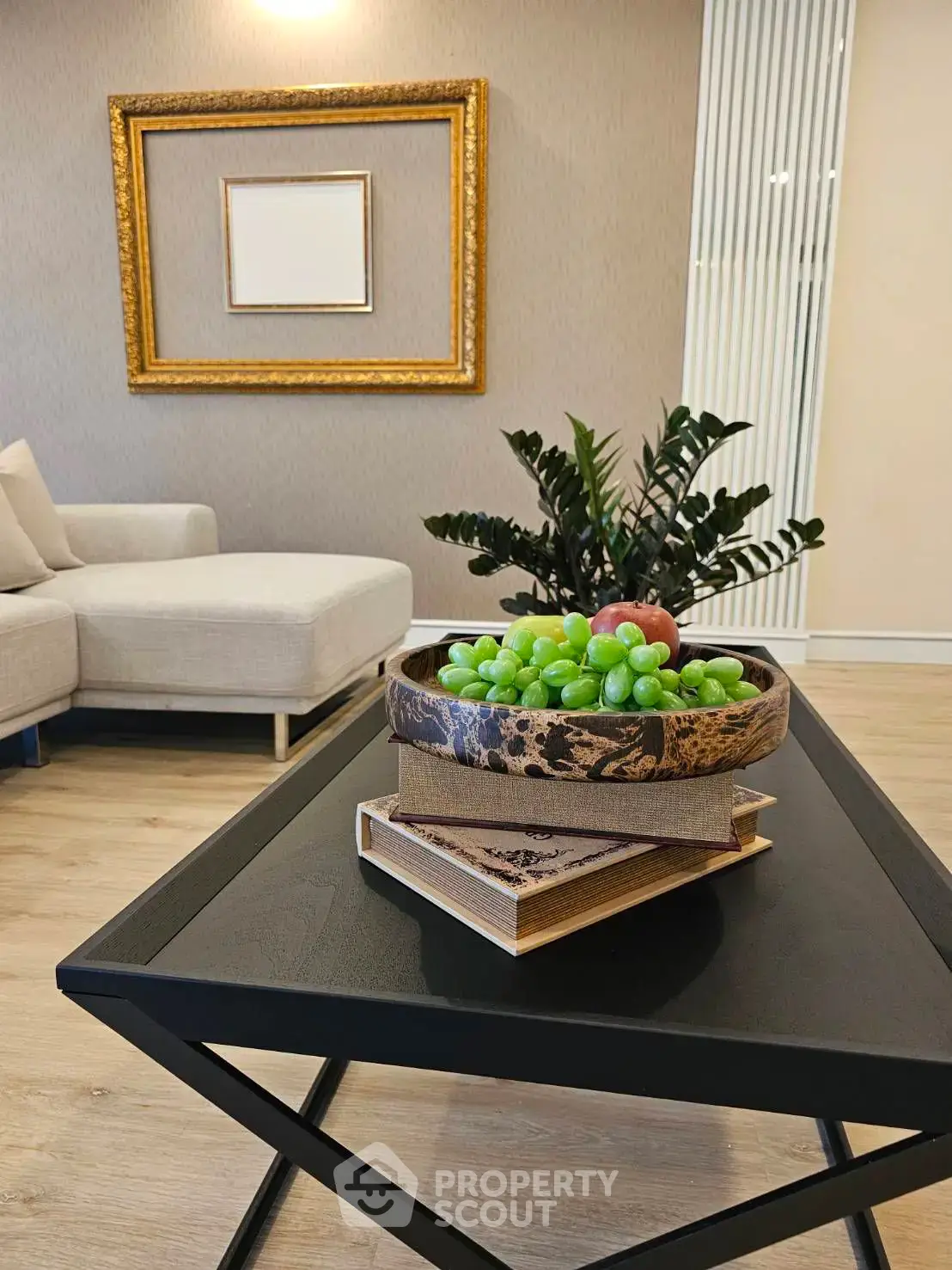 Stylish living room with modern decor, featuring a cozy sofa and elegant coffee table with fruit centerpiece.