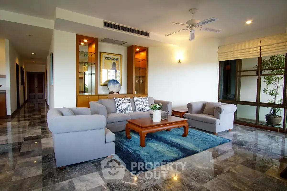 Spacious living room with elegant furniture and large windows in modern apartment.