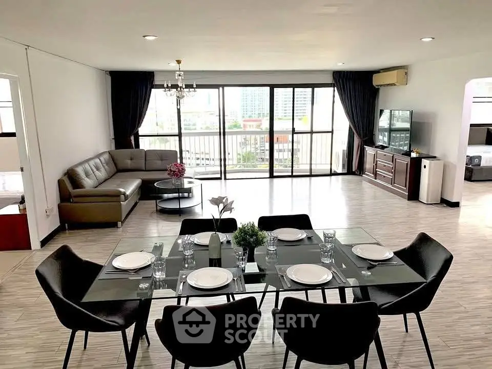 Spacious modern living room with dining area and large windows offering city views.