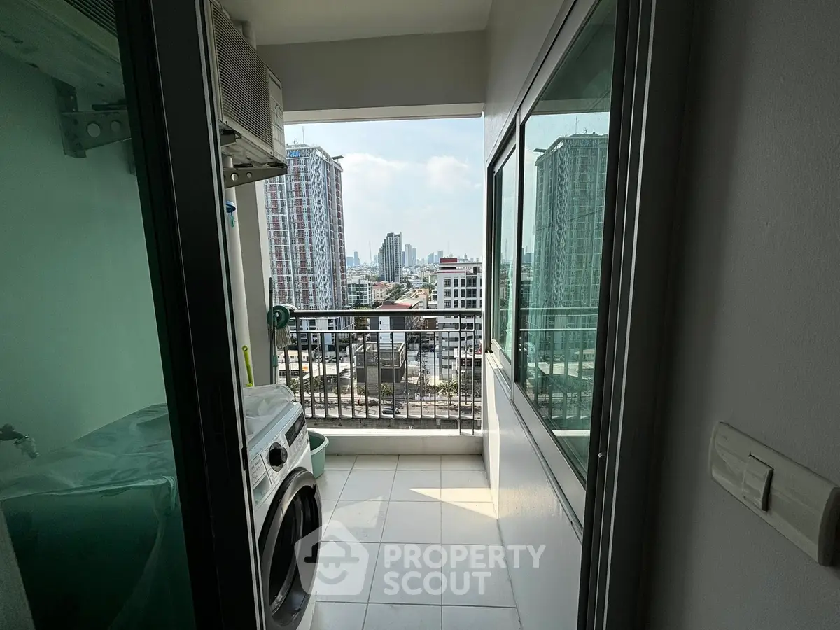 Modern apartment balcony with city view and laundry area, featuring washing machine and sleek glass doors.