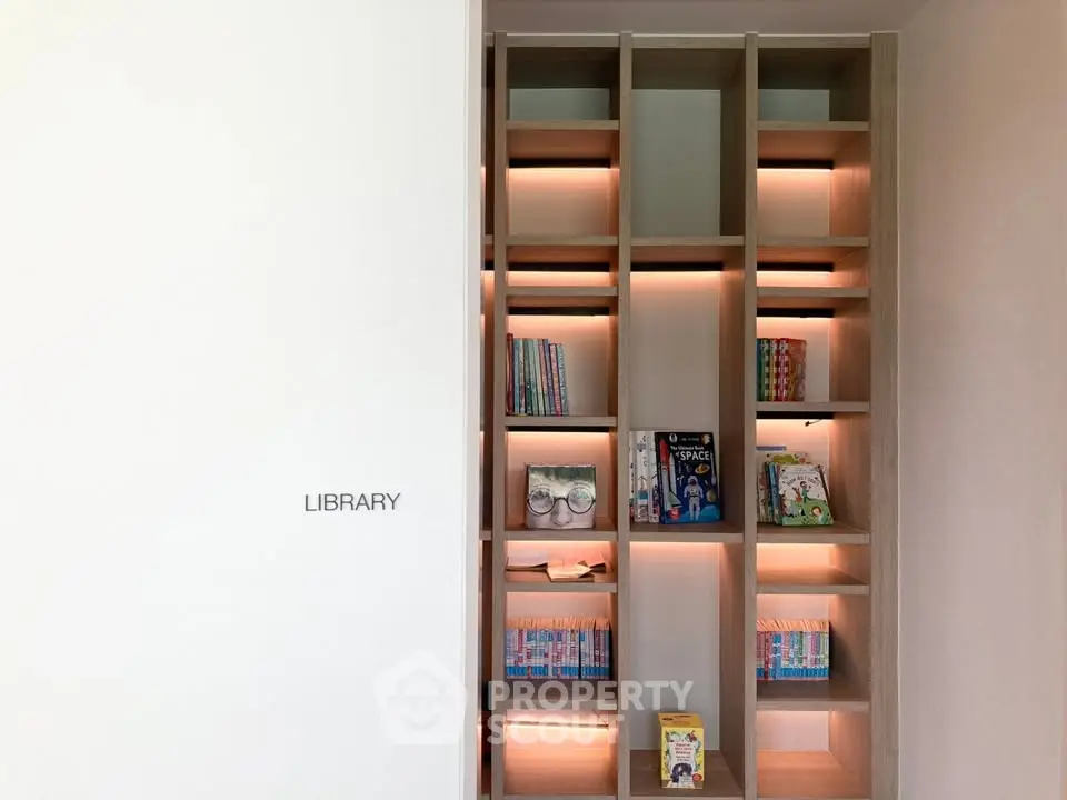 Modern library with stylish wooden shelves and ambient lighting in a contemporary building.